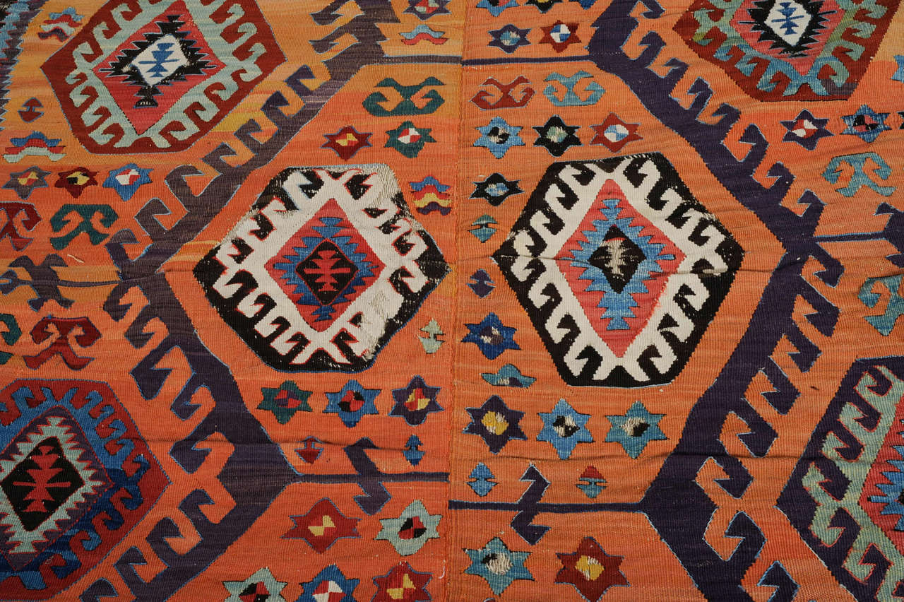 A stunning early Kilim from Central Anatolia distinguished by a rare apricot background, by a spectacular array of early colors including aubergine and by a bottom compartment decorated by stylized carnations (or Mother Goddess fertility figures